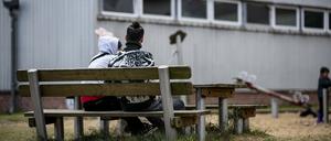 Zwei Asylsuchende in der Erstaufnahmeeinrichtung Eisenhüttenstadt sitzen auf einer Bank. 