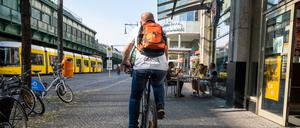 Fahrradfahrer fährt auf dem Gehweg auf der Schönhauser Allee in Berlin-Prenzlauer Berg.