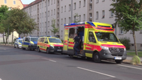 Vor einem Haus in Rathenow stehen Polizeiautos sowie Rettungswagen und das Auto eines Notarztes.