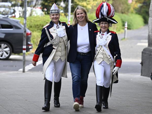 Die Karnevalistinnen Monika Kissing (l) und Bettina Schwerer (r) präsentieren zusammen mit der Präsidentin der „Ersten Damengarde Coeln 2014 e.V.“, Barbara Brüninghaus (M), ihre Karnevalskostüme in Form einer französischen Uniform.