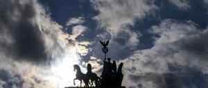 Die Quadriga auf dem Brandenburger Tor zeichnet sich im Gegenlicht der tief stehenden Sonne ab. 