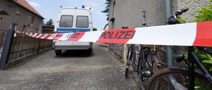 Ein Absperrband hängt vor einem Wohnhaus. Nach dem Fund einer Leiche in einem Haus im Landkreis Oberspreewald-Lausitz ermittelt die Mordkommission in Cottbus zu einem Gewaltverbrechen.