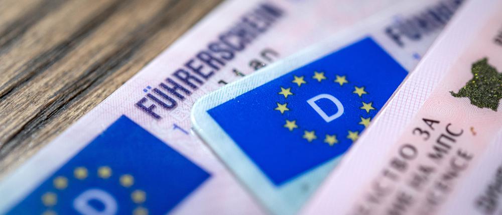 Ein bulgarischer und zwei deutsche Führerscheine liegen auf einem Tisch. Der Verkehrsausschuss im EU-Parlament stimmt über Vorschläge zu neuen EU-Führerscheinregeln ab. 