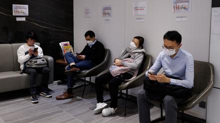 In einer Klinik in Hongkong warten Menschen auf eine Impfung.