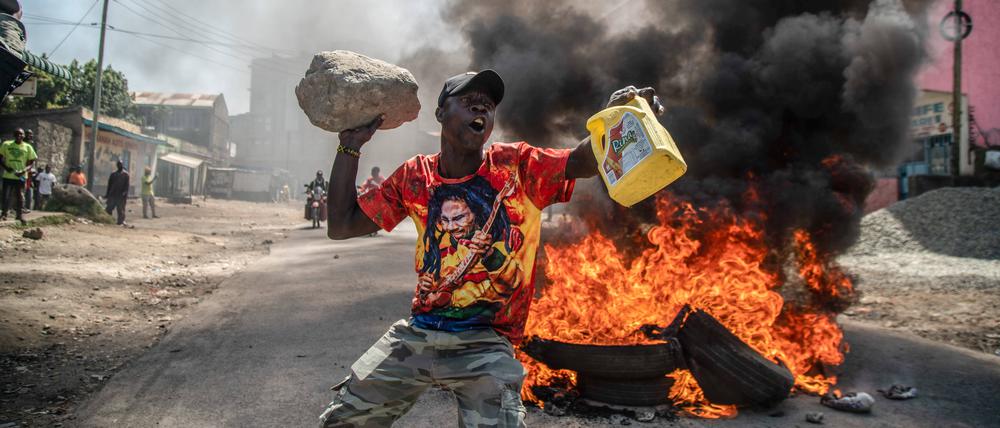 July 12, 2023, Nakuru, Kenya: A protester reacts in front of the burning tires during the protest against the government and high cost of living called by Kenyais opposition leader Raila Odinga. Nakuru Kenya - ZUMAs197 20230712_zaa_s197_001 Copyright: xJamesxWakibiax