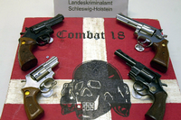 Sichergestellte Waffen und ein Schild der kriminellen Neonazi-Gruppe Combat 18 liegen im schleswig-holsteinischen Landeskriminalamt (LKA).