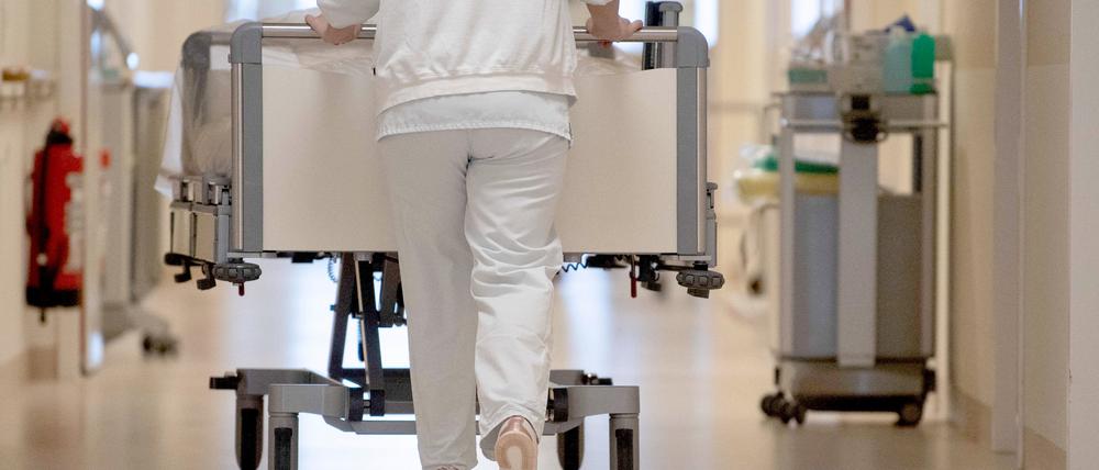 ARCHIV - 20.01.2020, Baden-Württemberg, ---: Eine Krankenpflegerin schiebt ein Krankenbett durch einen Flur. (zu dpa: «Umfrage: Über die Hälfte der Krankenhäuser macht Verlust») Foto: Marijan Murat/dpa +++ dpa-Bildfunk +++
