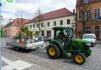 Ein Traktor mit Anhänger fährt durch die Altstadt und bringt Grünpflanzen auf das Gelände der Landesgartenschau. 