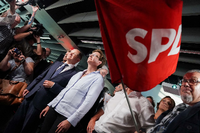 in Anhänger der SPD zeigt vor Beginn der SPD-Wahlparty zur Landtagswahl in Brandenburg das Victory-Zeichen und hält dabei eine SPD_Fahne in der Hand.