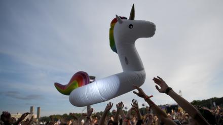 Ein aufblasbares Einhorn wird vom Publikum beim zweitägigen Musikfestival Lollapalooza auf dem Gelände des Olympiaparks in die Luft geworfen.