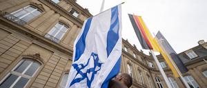 Die Flagge Israels wird von einem Mitarbeiter des Staatsministeriums Baden-Württemberg zwischen den Flaggen der EU, Deutschlands und Baden-Württembergs gehisst. (Archivbild)