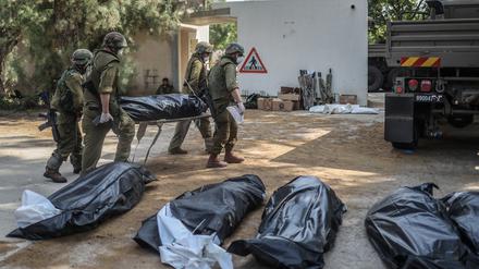 Israelische Streitkräfte bergen die Leichen israelischer Bewohner aus einem zerstörten Haus.