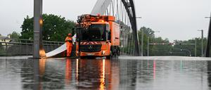 Ein Abpumpfahrzeug der Berliner Stadtreinigung BSR steht auf der überfluteten Freybrücke an der Heerstraße. Aufgrund der starken Regenfälle ist die Straße in Teilen nicht befahrbar.