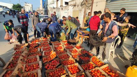 Palästinenser kaufen Gemüse und andere Lebensmittel auf einem Markt.