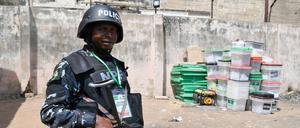TOPSHOT - An anti riot Police officer stands meters away from ballot boxes used during the presidential elections at the state headquarters of Independent National Electoral Commission (INEC) in Yola on February 26, 2023 the day after Nigeria's presidential and general election. (Photo by PIUS UTOMI EKPEI / AFP)