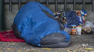 Ein Obdachloser in einen Schlafsack gehüllt unter einem Dachvorsprung vor dem  Berliner Zoo. 