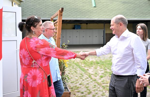 Bundeskanzler Olaf Scholz begrüßt Martina Weber, Wirtin des Lokals „Glücksfisch“.