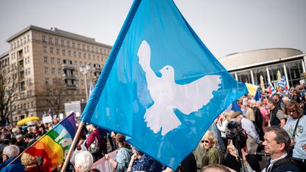Eine Flagge mit der Friedenstaube ist auf dem traditionellen Ostermarsch unter dem Motto «Kriegstüchtig – Nie wieder» zu sehen. Im Zentrum des diesjährigen Ostermarsches stehen der Israelkonflikt und der russische Angriffskrieg in der Ukraine.