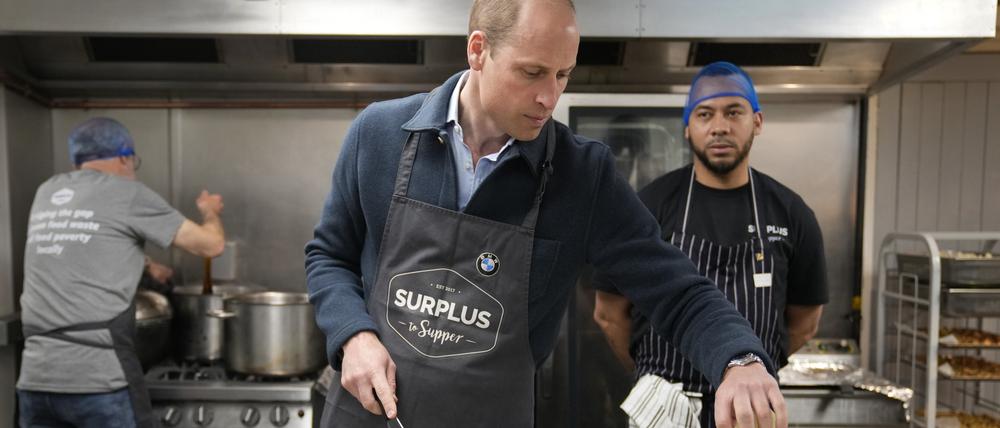 Der britische Prinz William schneidet Sellerie und hilft bei der Herstellung einer Bolognesesauce während eines Besuchs bei Surplus to Supper in Sunbury-on-Thames. 