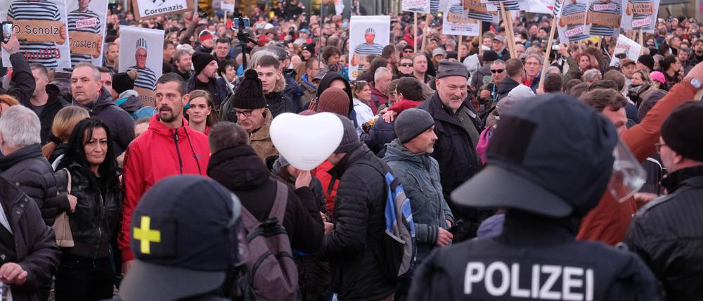Teilnehmer einer Kundgebung von Kritikern der Coronamaßnahmen der Bundesregierung stehen auf dem Augustusplatz in Leipzig der Polizei gegenüber. 