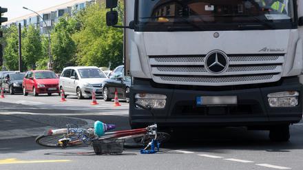 23.05.2019, Berlin: Ein Fahrrad liegt vor einem Lkw an der Kreuzung Josef-Orlopp-Straße/Möllendorffstraße. Beim Abbiegen nach rechts in die Josef-Orlopp-Straße erfasste der 13,5 Tonner eine Radfahrerin. Sie wurde bei dem Zusammenstoß lebensgefährlich verletzt. Foto: Paul Zinken/dpa - ACHTUNG: Kennzeichen aus rechtlichen Gründen gepixelt +++ dpa-Bildfunk +++