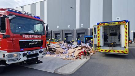 Die Potsdamer Feuerwehr bei einem Rettungseinsatz im Gewerbegebiet Friedrichspark. Einsatzkräfte entleeren gerade eine Papierpresse, in die zuvor ein Mensch geraten ist. 
