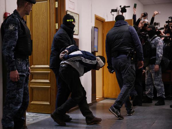Einer der Verdächtigen wird am 24. März 2024 im Bezirksgericht Basmanny von russischen Strafverfolgungsbeamten eskortiert, bevor in Untersuchungshaft genommen wird.
