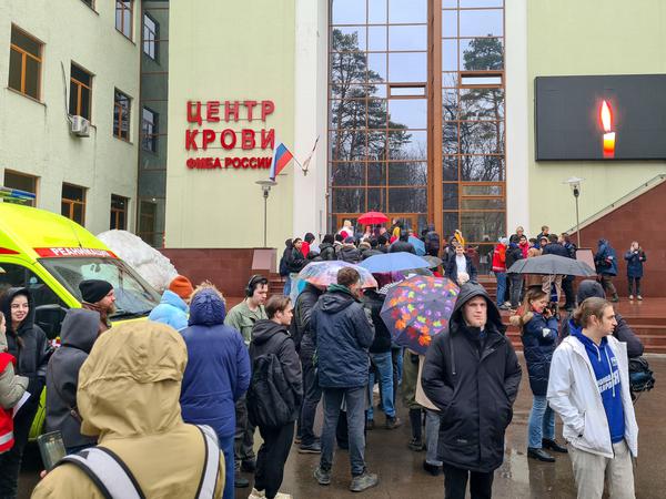 Menschen in Moskau warten vor einem Gebäude, wo Blut für die Verletzten gespendet werden kann.