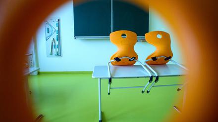 Stühle stehen in einem leeren Klassenzimmer auf einem Tisch. 