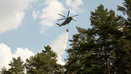 Bundeswehr im Einsatz: Ein Hubschrauber lässt in Fichtenwalde bei Potsdam Wasser ab, um einen Waldbrand zu löschen (Archivbild).