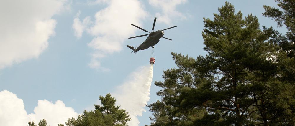 Bundeswehr im Einsatz: Ein Hubschrauber lässt in Fichtenwalde bei Potsdam Wasser ab, um einen Waldbrand zu löschen (Archivbild).