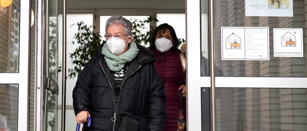 Frauen, die ein Gesundheitszentrum im Nordwesten Spaniens verlassen, tragen eine Maske. 