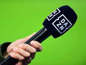 Die Hand eines Reporters hält bei einem Interview vor dem Spiel ein Mikrofon mit der Aufschrift Dazn.