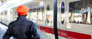 Ein DB-Mitarbeiter steht neben einem ICE-Zug an einem Gleis im Hauptbahnhof Hannover.