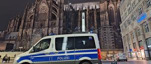 Ein Einsatzfahrzeug der Polizei steht vor dem Kölner Dom.