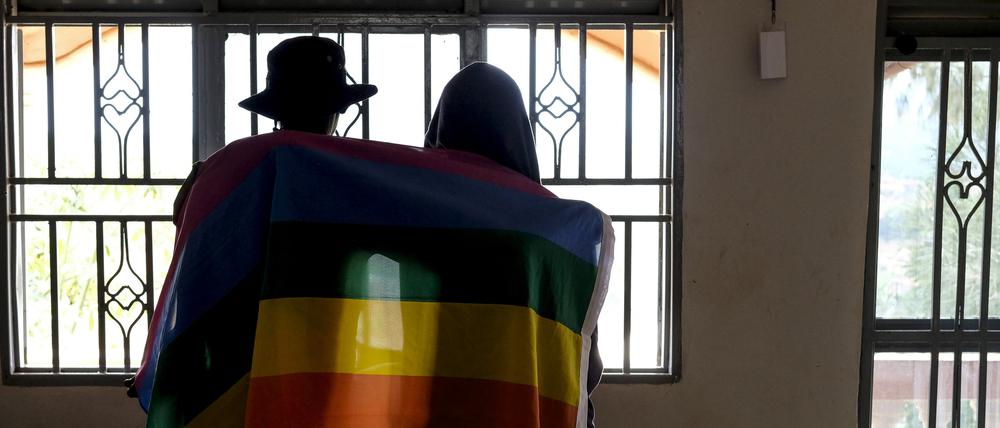 Ein ugandisches Paar bedeckt sich mit einer Pride-Fahne. 