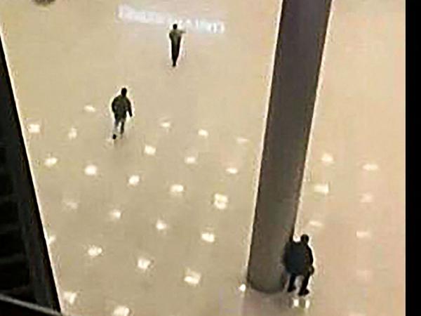 Dieses Bild, das von AFP TV aufgenommen wurde, zeigt nicht identifizierte Bewaffnete, die sich am späten 22. März 2024 auf die Türen der Konzerthalle zubewegen. 