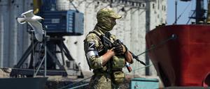 Ein russischer Soldat im ukrainischen Mariupol bewacht einen Pier mit einem Getreidespeicher. 