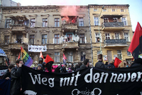 Verkleidete Demonstranten protestierten mit Pyrofackeln auf dem Balkon eines Wohnhauses an der Demoroute gegen das neue Brandenburger Polizeigesetz.