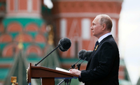 Putin ist während seiner Rede auf einem Bildschirm zu sehen.