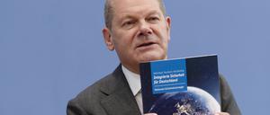 Kanzler Olaf Scholz (SPD) mit der Broschüre zur neuen Nationalen Sicherheitsstrategie. 
