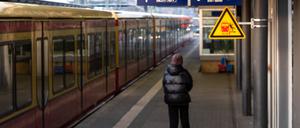 Ein Fahrgast steht auf einem leeren Bahngleis des Potsdamer Hauptbahnhofs, während ein Display über den laufenden Streik informiert. 