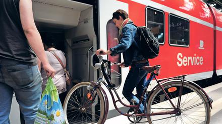 Eine junge Frau besteigt am Freitag (10.06.2011) auf dem Ostbahnhof in Berlin einen Zug mit ihrem Fahrrad. Der Radtransport per Bahn wird zu Spitzenzeiten wie an Pfingsten manchmal zum Risiko. Die Radler kämpfen nach Angaben des Fahrgastverbandes Pro Bahn häufig um die knappen Plätze im Regionalzug. Foto: Hannibal dpa/lbn +++(c) dpa - Bildfunk+++