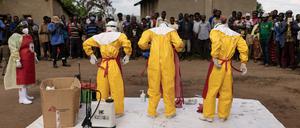 Mitarbeiter des Roten Kreuzes ziehen Schutzanzüge an, bevor sie am 13. Oktober  in Mubende einen 3-jährigen Jungen beerdigen, der wohl an Ebola verstorben ist.