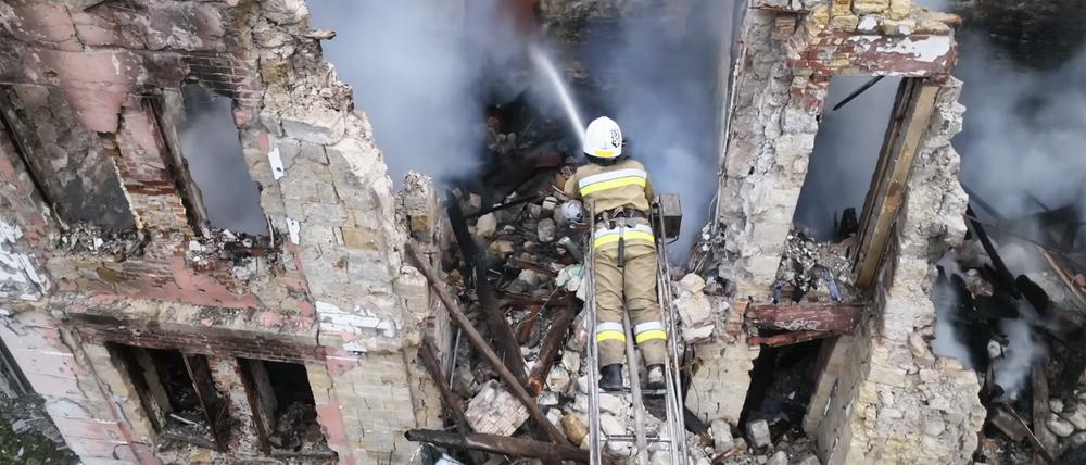 Rettungskräftearbeite löschen ein Feuer in einem Wohnhaus in Mikolajiw.