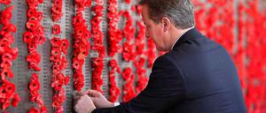 British Prime Minister David Cameron places a poppy along the Roll of Honour during a visit to the Australian War Memorial in Canberra.