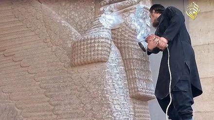 Schutzlos. Gegen die Barbarei des IS ist der Schutzgenios in Ninive machtlos. Die 2600 Jahre alten Skulpturen aus hartem Stein sind Meisterwerke neuassyrischer Bildhauerkunst. Das Bild ist ein Screenshot aus einem Propagandavideo der Terrormiliz.