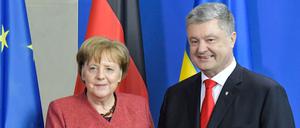 Bundeskanzlerin Angela Merkel und der ukrainische Präsident Petro Poroschenko geben sich nach einer gemeinsamen Pressekonferenz nach Gesprächen in Berlin die Hand (Archivbild).