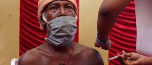 Ein Mitarbeiter des Gesundheitswesens impft einen Mann im indischen Chennai. 