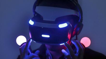 Ein Fachbesucher testet auf der Spielemesse Gamescom mit einer VR-Brille (Virtual Reality) von Sony ein Computerspiel.